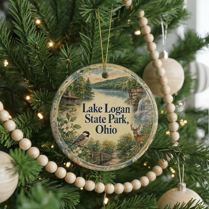 A round ornament hanging on a Christmas tree, featuring a scenic image of Lake Logan State Park, Ohio.