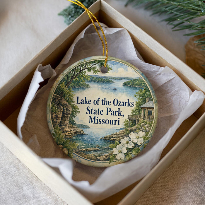 A decorative ornament in a box, featuring a scenic image of Lake of the Ozarks State Park, Missouri.