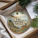 A decorative ornament with a scenic image of Lake Sakakawea State Park, North Dakota, featuring a deer, pine trees, and a sunset landscape.