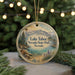 A circular ornament with a scenic landscape of Lake Tahoe, Nevada, featuring mountains, pine trees, and a lake.