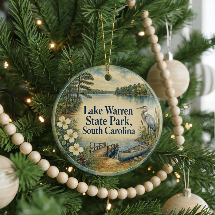 A round ornament hanging on a Christmas tree, featuring a scenic image of Lake Warren State Park in South Carolina.