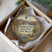 A round ornament with a scenic image of Leasburg Dam, Leasburg State Park, and New Mexico, placed in a box with a white tissue paper lining.