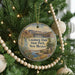 A round ornament hanging on a Christmas tree, featuring an illustration of Leasburg Dam, Leasburg, New Mexico, and a scenic landscape.