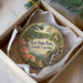 A round ornament with a scenic landscape of Lee State Park, South Carolina, displayed in a box with a white tissue paper lining.