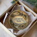 A round ornament with a painting of Lewis and Clark exploring the Caves of State Park in Montana.