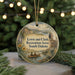 A round ornament with a scenic landscape featuring a river, mountains, and people canoeing, hanging from a string.