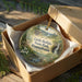 A decorative ornament in a brown box, featuring a scenic image of Little Buffalo State Park, Pennsylvania.