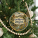 A round ornament hanging on a Christmas tree, featuring a scenic landscape of Little Missouri State Park, North Dakota.