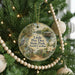 A round ornament hanging on a Christmas tree, featuring a scenic image of Little Pee Dee State Park in South Carolina.