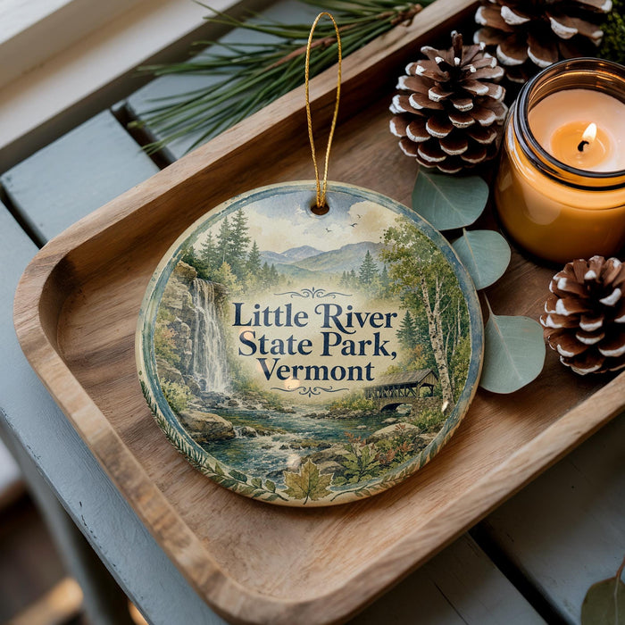 A wooden tray with a decorative ornament featuring a scenic image of Little River State Park, Vermont, and pine cones.