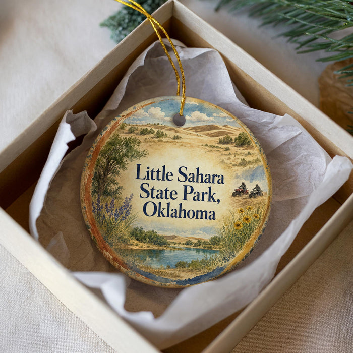 A decorative ornament in a box, featuring a scenic landscape with a lake, mountains, and wildflowers.