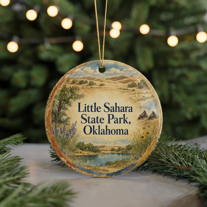 A round ornament with a scenic landscape of Little Sahara State Park, Oklahoma, featuring a river, mountains, and greenery.