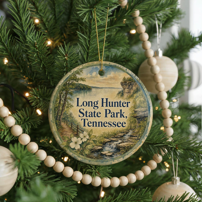 A round ornament hanging on a Christmas tree, featuring a scenic landscape of Long Hunter State Park, Tennessee.