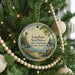 A round ornament hanging on a Christmas tree, featuring a lighthouse and a scenic view of Lake Chautauqua in New York.