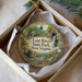 An ornament in a box, featuring a scenic image of Lost River State Park in West Virginia.