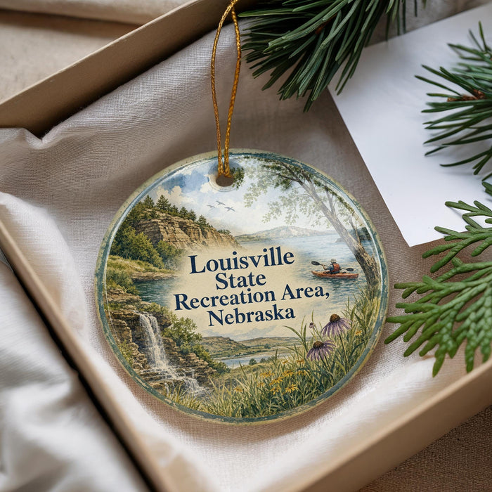 A decorative ornament with a scenic landscape of a waterfall, mountains, and a person kayaking in the Missouri State Recreation Area, Nebraska.