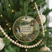 A circular ornament on a Christmas tree, featuring a scenic landscape with a waterfall and pine trees, with the text "Lyman Run State Park, Pennsylvania" displayed on it.