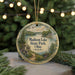 A decorative ornament with a scenic image of Madison Lake State Park, Ohio, featuring a path, trees, and a bird, hanging in front of a blurred background with twinkling lights.
