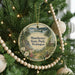 A round ornament hanging on a Christmas tree, featuring a scenic image of Manchester State Park in Washington.