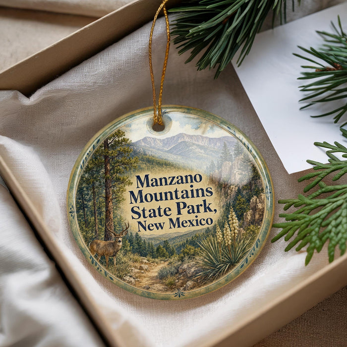 A decorative ornament with a scenic image of the Manzanilla Mountains State Park in New Mexico, featuring a deer and a forest landscape.