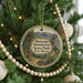 A round ornament hanging on a Christmas tree, featuring a scenic image of the Manzanos Mountains State Park in New Mexico.