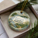 A decorative ornament in a box, featuring a scenic landscape with a lake, trees, and birds, along with the text "Marsh Creek State Park, Pennsylvania".
