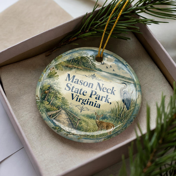 A decorative ornament in a box, featuring an illustration of a park scene with a deer, birds, and a bridge.