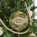 A round ornament hanging on a Christmas tree, featuring an illustration of a historic site and the text "Mastodon State Historic Site, Missouri".