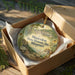 A decorative ornament in a wooden box, featuring an illustration of a historic site and the text "Mastodon State Historic Site, Missouri".