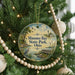 A round ornament hanging on a Christmas tree, featuring a scenic image of Maumee Bay State Park, Ohio.