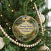 A round ornament hanging on a Christmas tree, featuring a scenic image of the Meeman-Shelby Forest State Park in Tennessee.