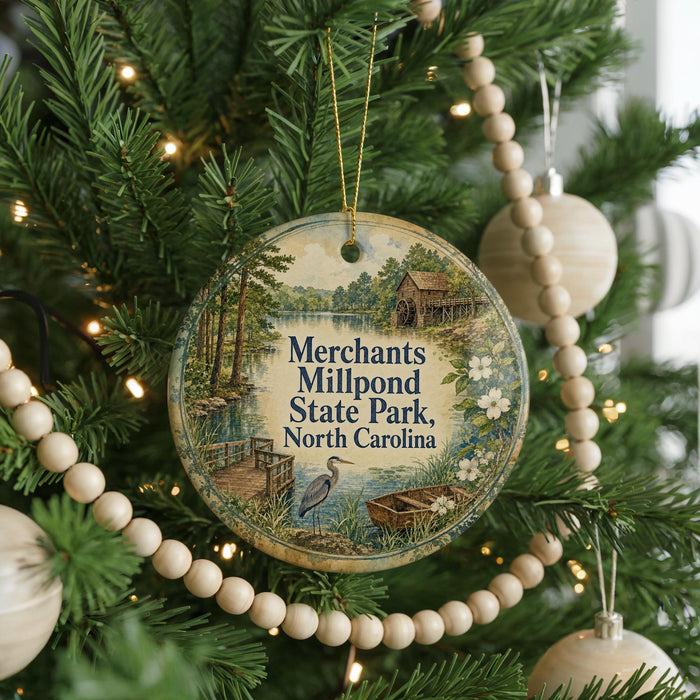A round ornament hanging on a Christmas tree, featuring a scenic image of Mill Pond State Park in North Carolina.