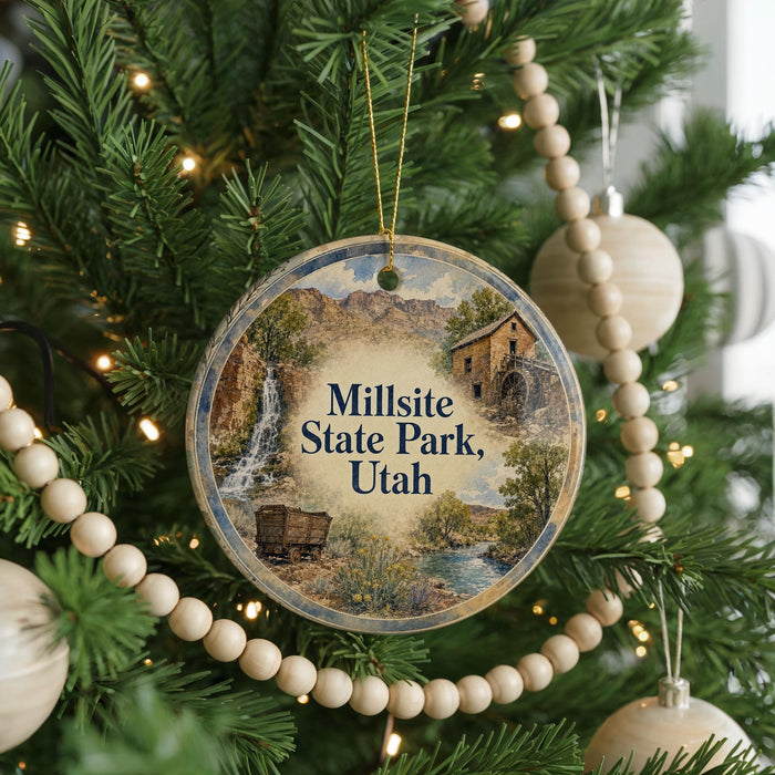 A round ornament hanging on a Christmas tree, featuring a scenic image of Millsite State Park in Utah.