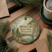 A round ornament with a scenic landscape of Mirror Lake State Park, Wisconsin, hangs on a wooden surface.