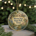 A round ornament with a painting of Mission Tejas State Park, Texas, featuring a church, trees, and a deer, hanging from a string.