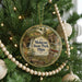 A circular ornament hanging on a Christmas tree, featuring a scenic image of Mohican State Park, Ohio.