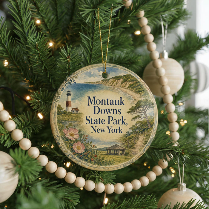 A round ornament hanging on a Christmas tree, featuring a lighthouse and a coastal landscape.