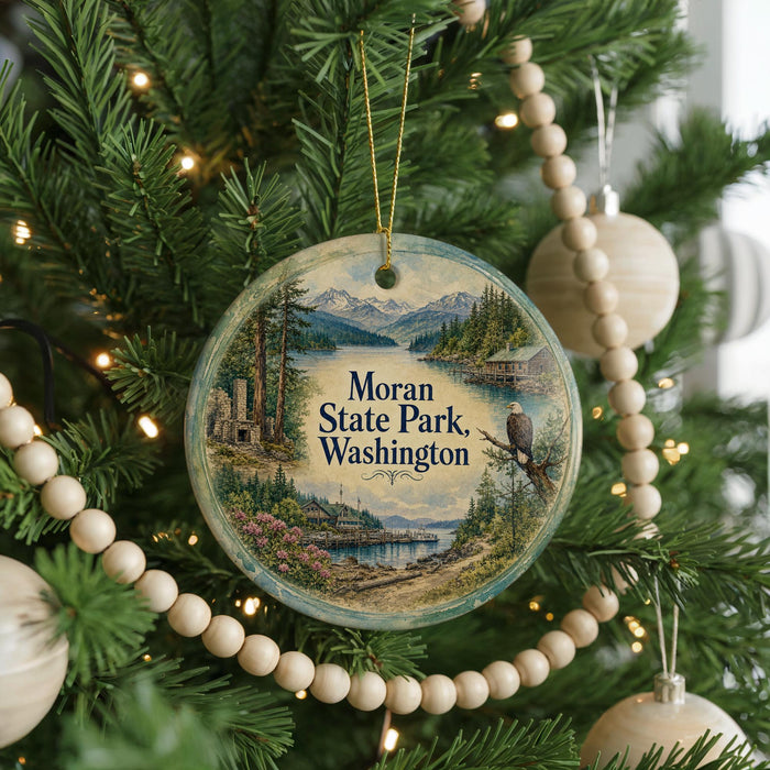A round ornament hanging on a Christmas tree, featuring a scenic landscape with mountains, trees, and a lake.