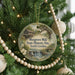 A round ornament hanging on a Christmas tree, featuring a scenic image of Musgrove Mill, South Carolina.
