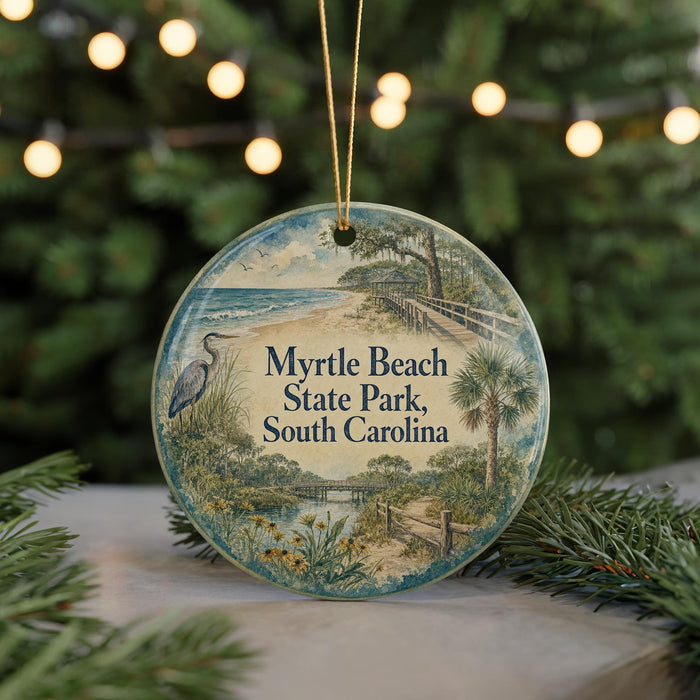 A round ornament with a beach scene and a bird, hanging on a string.