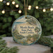 A round ornament with a beach scene and a bird, hanging on a string.