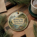 A round ornament with a scenic image of Mystery Bay State Park, Washington, hanging on a wooden surface.
