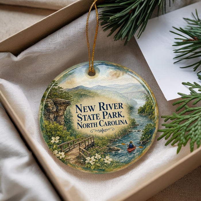 A decorative ornament with a scenic image of a river, bridge, and mountains, along with the text "New River State Park, North Carolina".