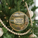 A Christmas tree decorated with ornaments, including a circular ornament with a scenic landscape of Newton Hills State Park, South Dakota, and a beaded ornament.