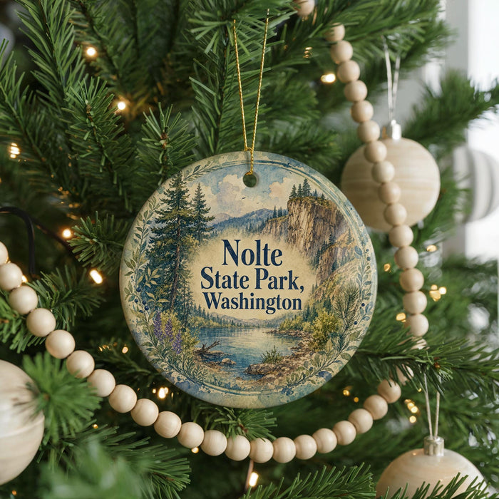 A Christmas tree decorated with ornaments, including a round ornament with a scenic landscape and the text "Nolte State Park, Washington".