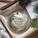 A round ornament with a scenic image of a lighthouse and a bench, surrounded by greenery, is displayed in a box.