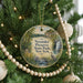 A round ornament hanging on a Christmas tree, featuring a scenic image of a waterfall surrounded by lush greenery.