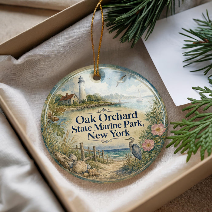 A decorative ornament with a lighthouse and a coastal scene, placed in a box with pine branches.