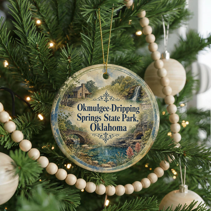 A round ornament hanging on a Christmas tree, featuring a scenic image of Okmulgee Drip Springs State Park in Oklahoma.