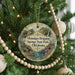 A round ornament hanging on a Christmas tree, featuring a scenic image of Okmulgee Drip Springs State Park in Oklahoma.